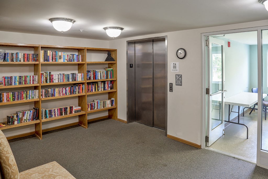a library with bookshelves and a glass door