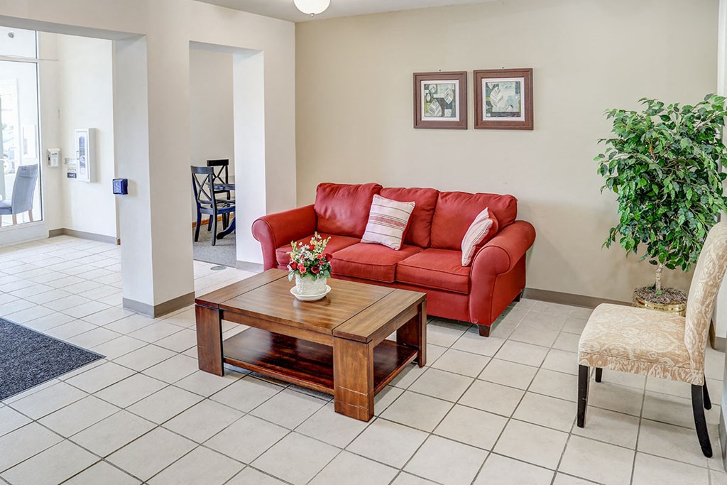 a living room with a red couch and a coffee table
