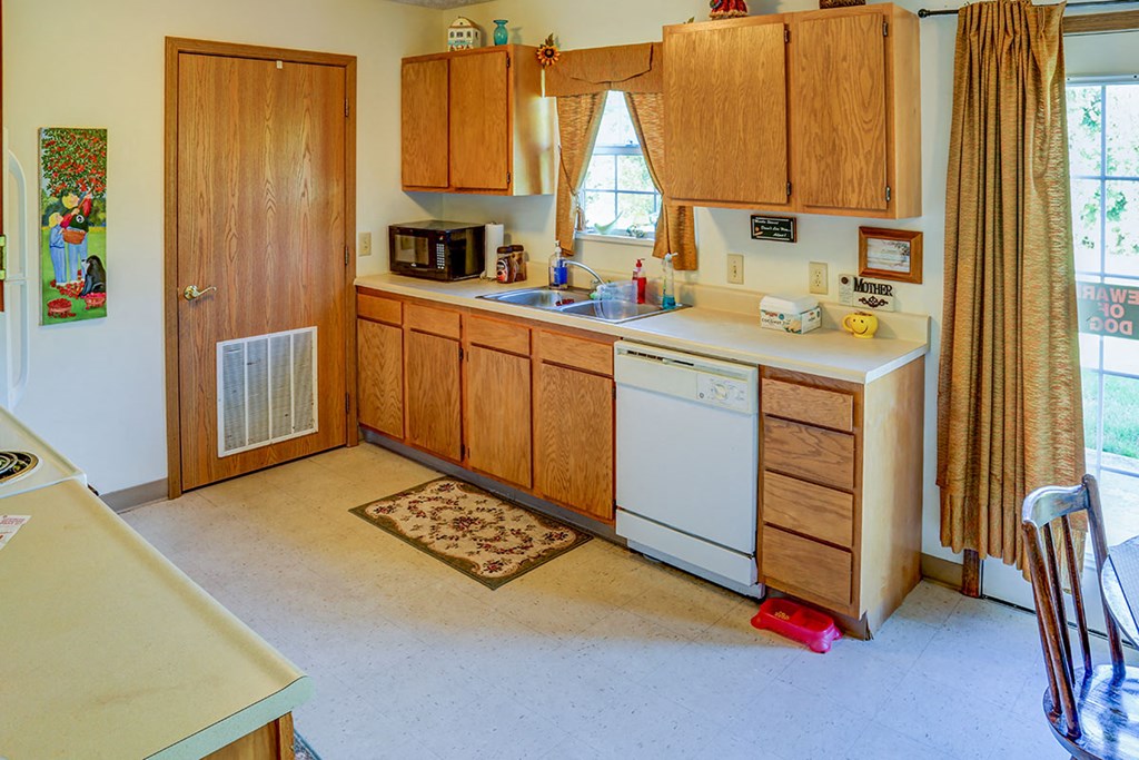 a kitchen with wooden cabinets and a white dishwasher