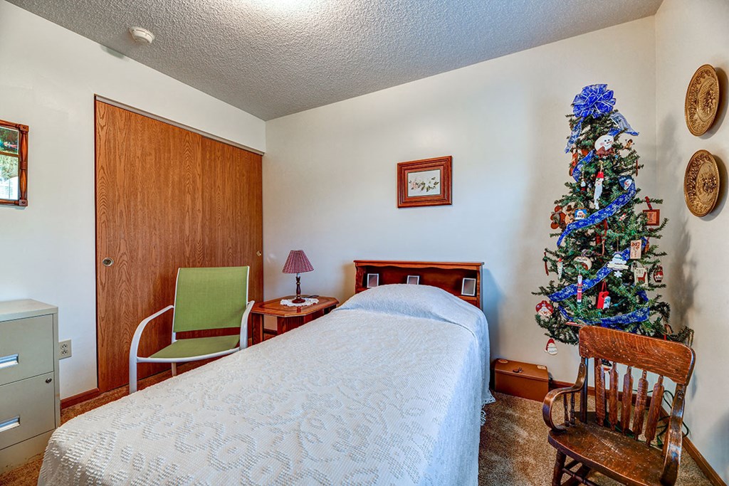 a bedroom with a bed and a christmas tree
