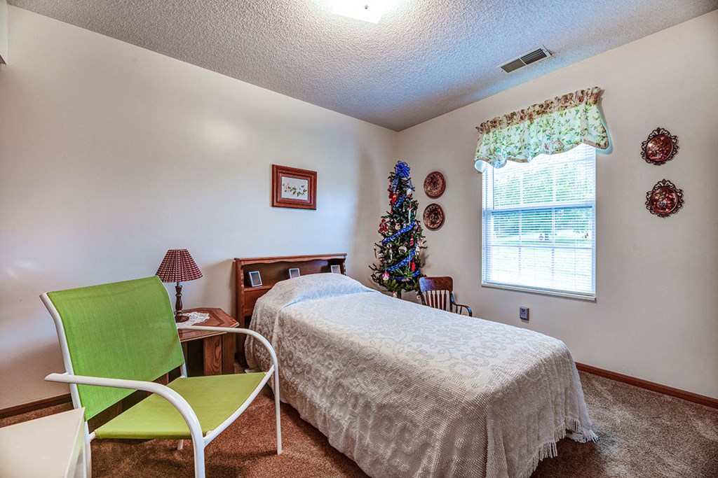 a bedroom with a bed and a christmas tree