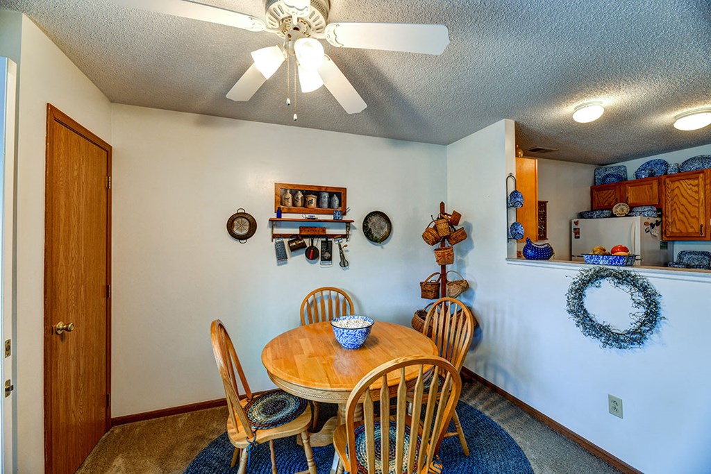 a dining room with a table and chairs and a ceiling fan