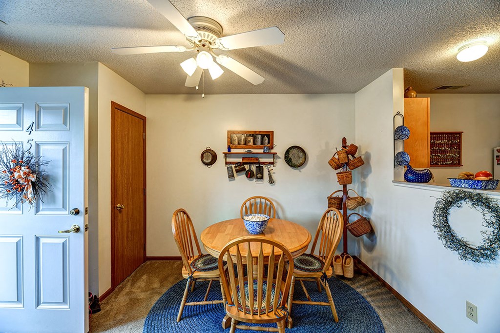 a dining room with a table and chairs and a ceiling fan