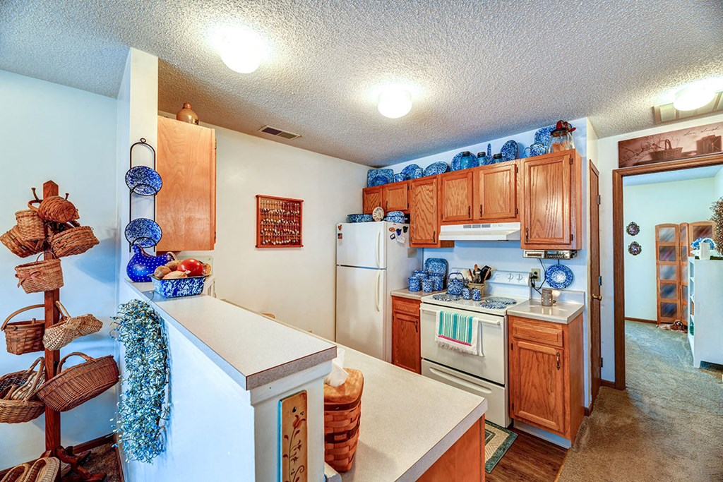 a kitchen with white appliances and wooden cabinets