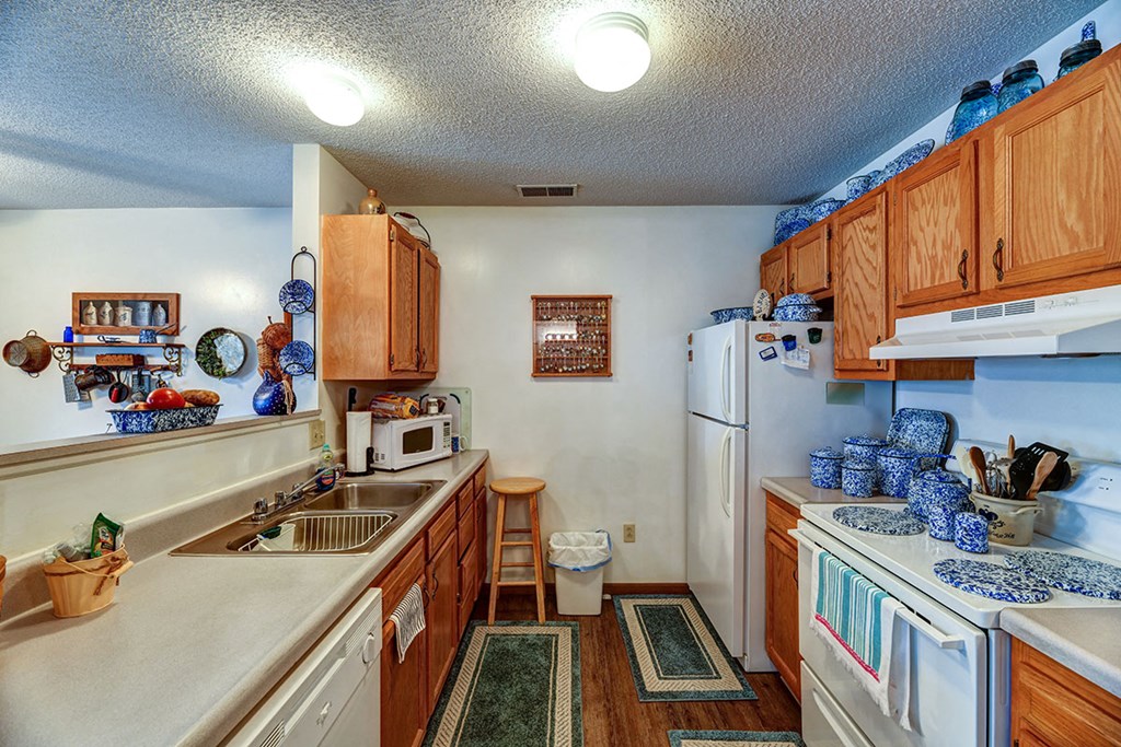 a kitchen with white appliances and wooden cabinets