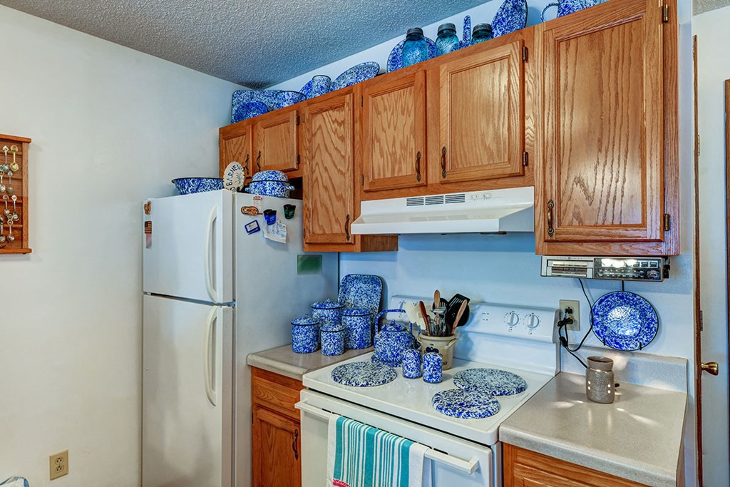 a kitchen with white appliances and wood cabinets