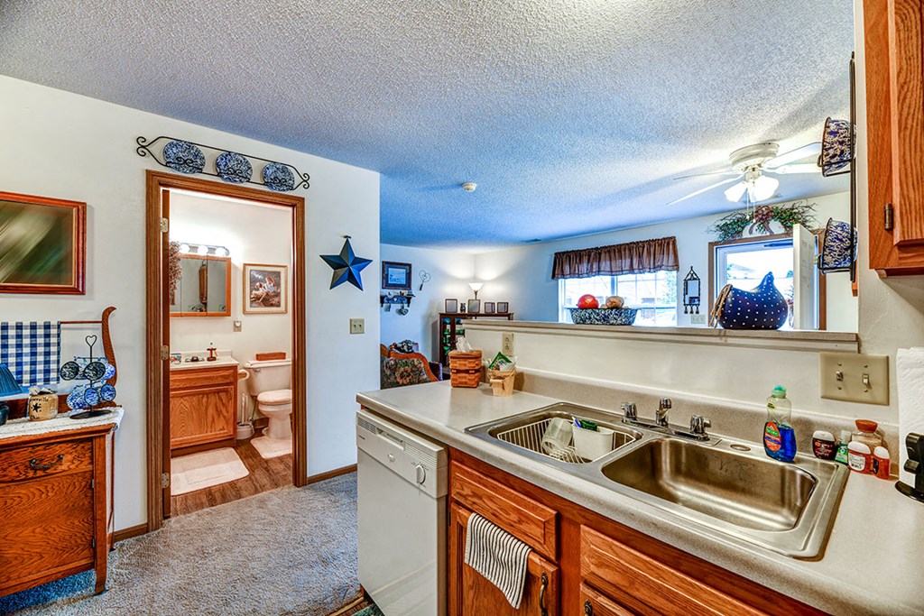 a kitchen with a sink and a door to a bathroom