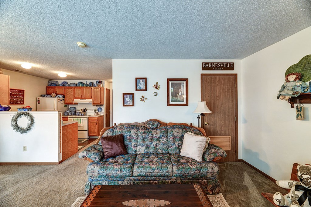 a living room with a couch and a kitchen