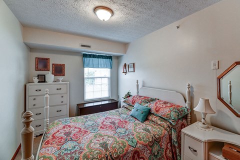 a bedroom with a bed and a dresser and a window