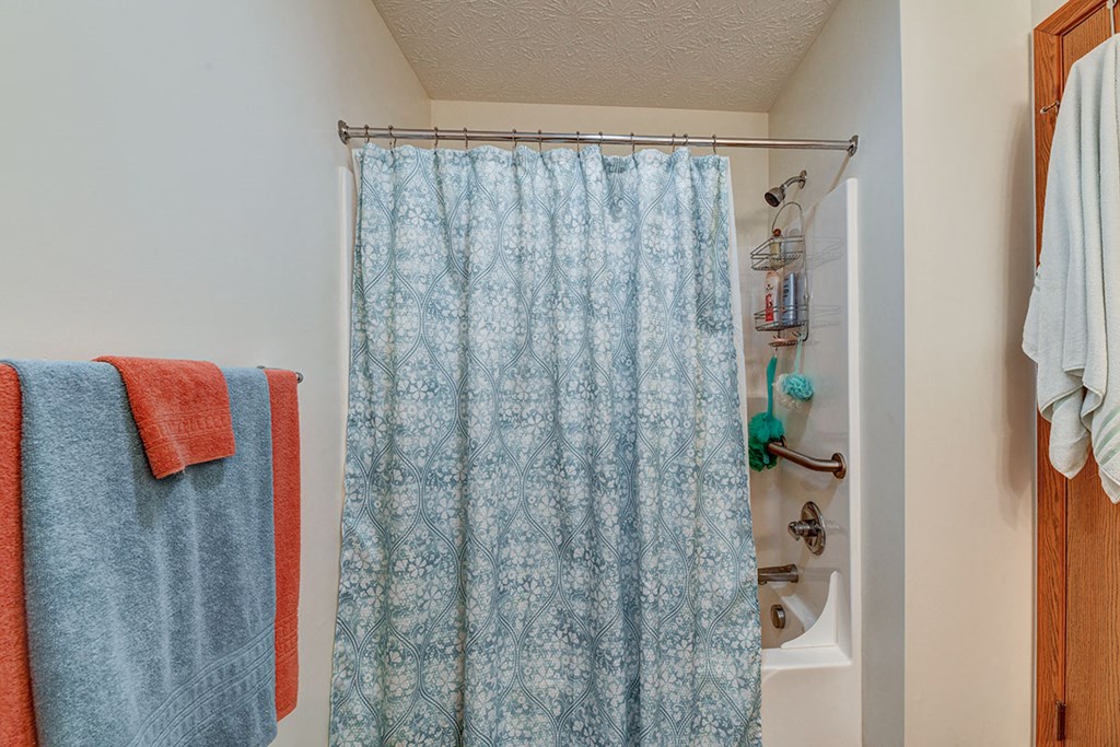 a bathroom with a blue shower curtain and some towels