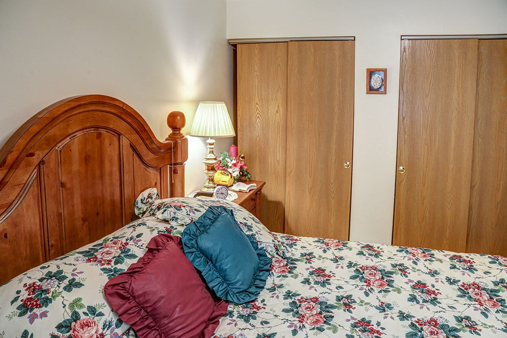 a bedroom with a large bed and a wooden headboard