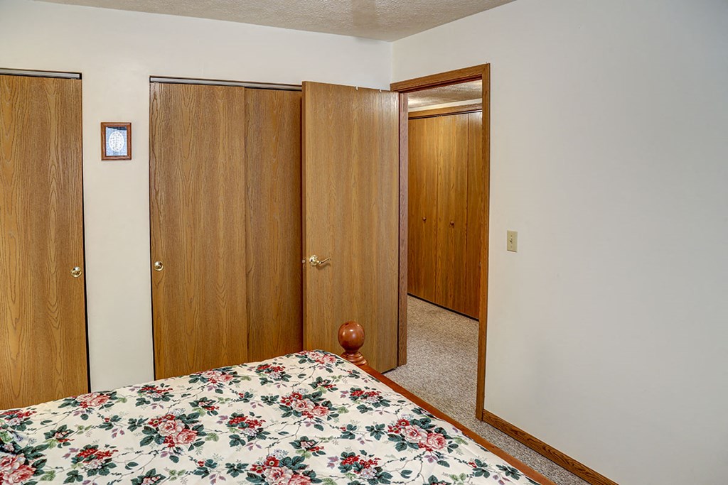 a bedroom with a bed and two closet doors