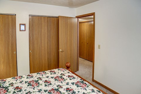 a bedroom with a bed and two closet doors