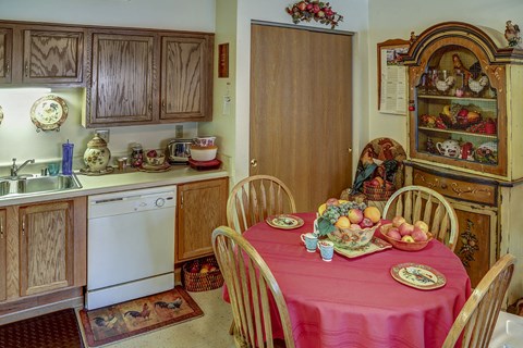 a kitchen with a table with a pink tablecloth