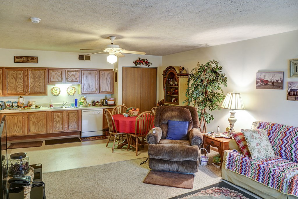 a living room and kitchen with a couch and a chair