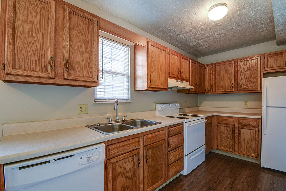 a kitchen with white appliances and wooden cabinets