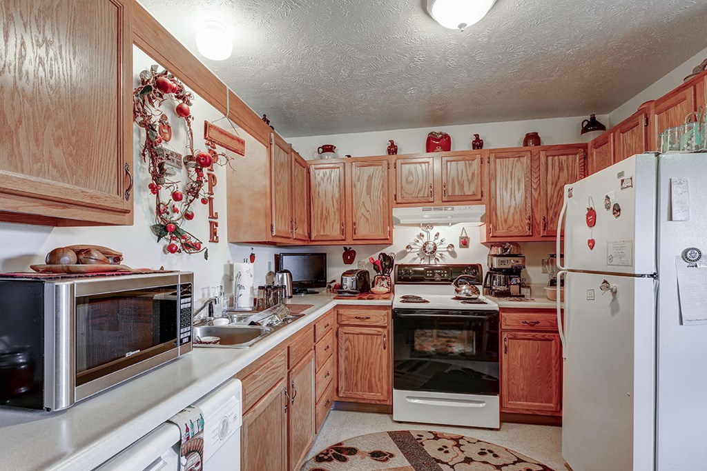 a kitchen with white appliances and wooden cabinets