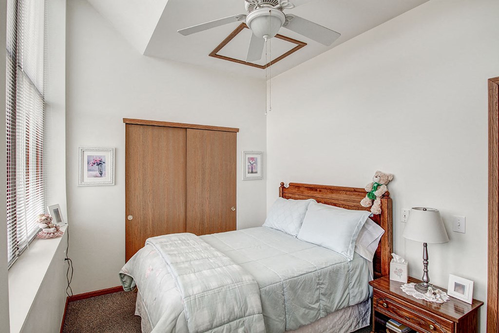 a bedroom with a bed and a ceiling fan