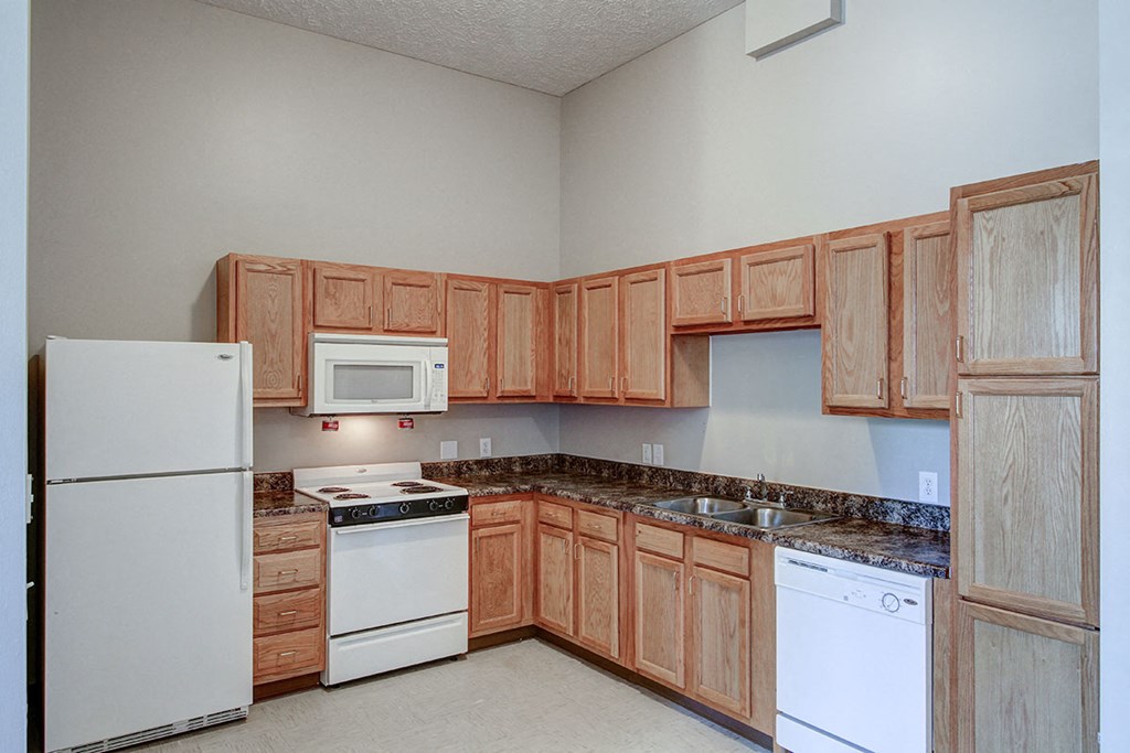 a kitchen with white appliances and wooden cabinets