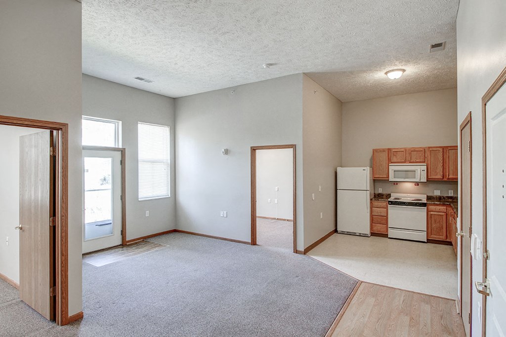 an empty living room with a kitchen in it