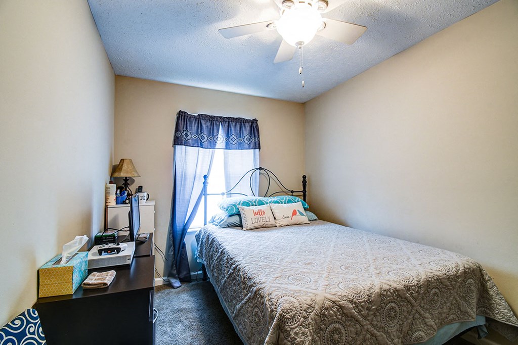a bedroom with a bed and a ceiling fan