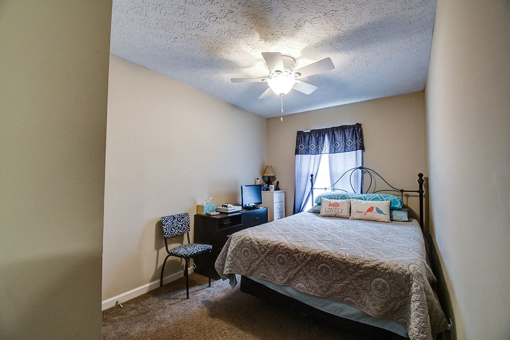 a bedroom with a bed and a ceiling fan