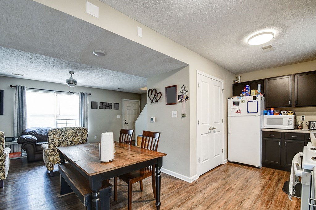 a kitchen and living room with a table and a refrigerator