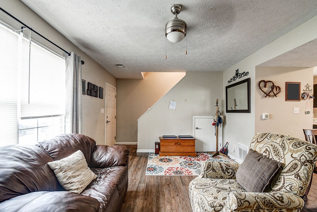 a living room with a couch and a chair and a window