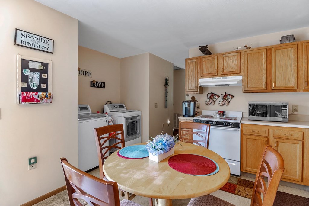 a kitchen with appliances and a table with chairs