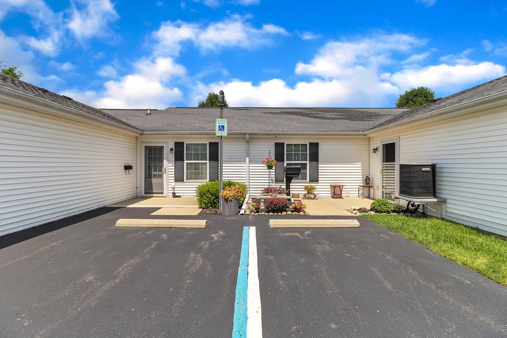 a parking lot in front of a white building with a blue sky