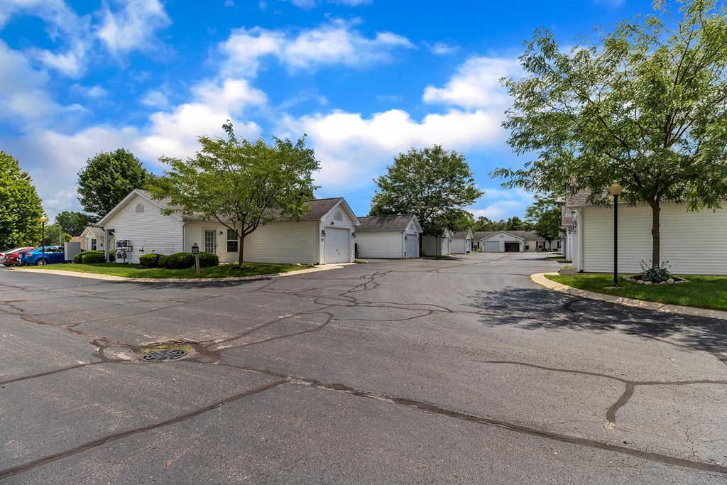 an empty street in a neighborhood with houses and trees