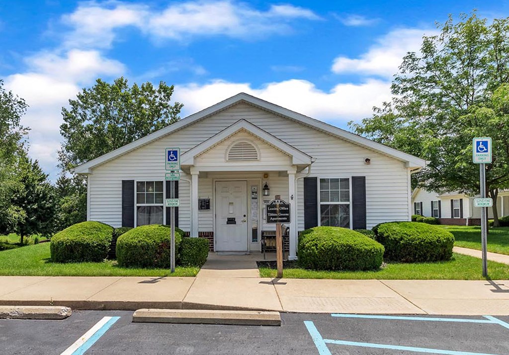 a white church building with a driveway and a parking lot
