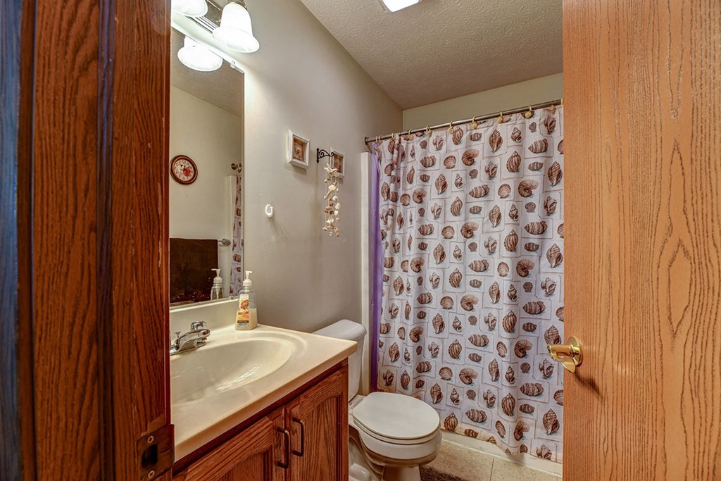 a bathroom with a shower and a sink and a toilet