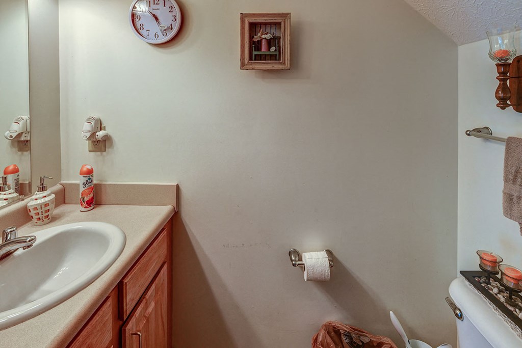 a bathroom with a sink and a clock on the wall