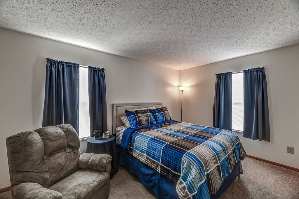 a bedroom with a bed and a chair