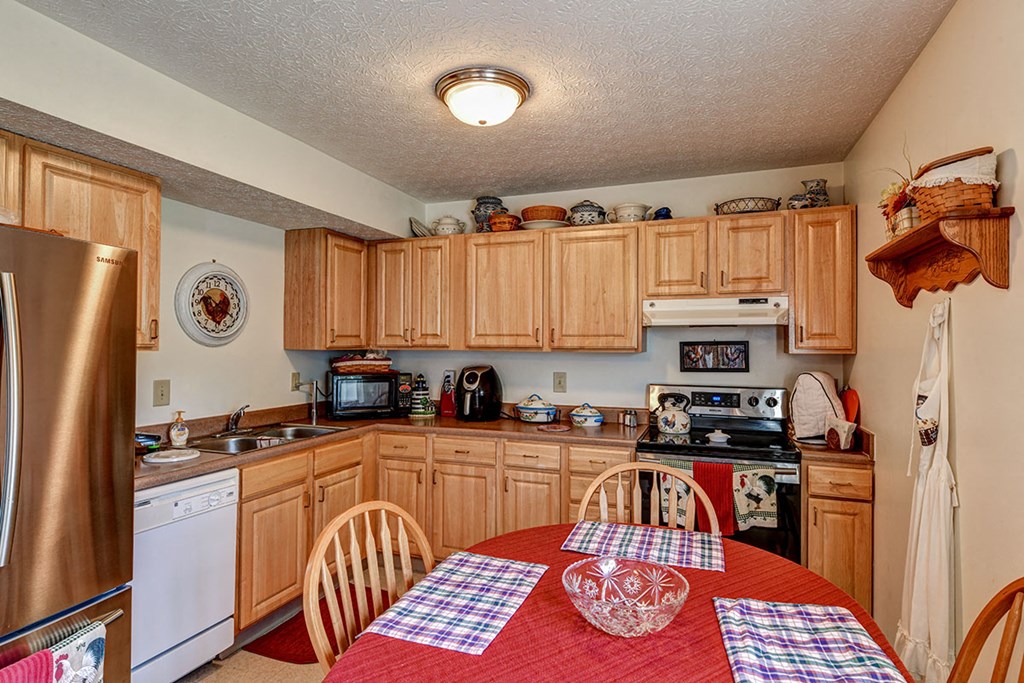 a kitchen with wooden cabinets and a table with chairs