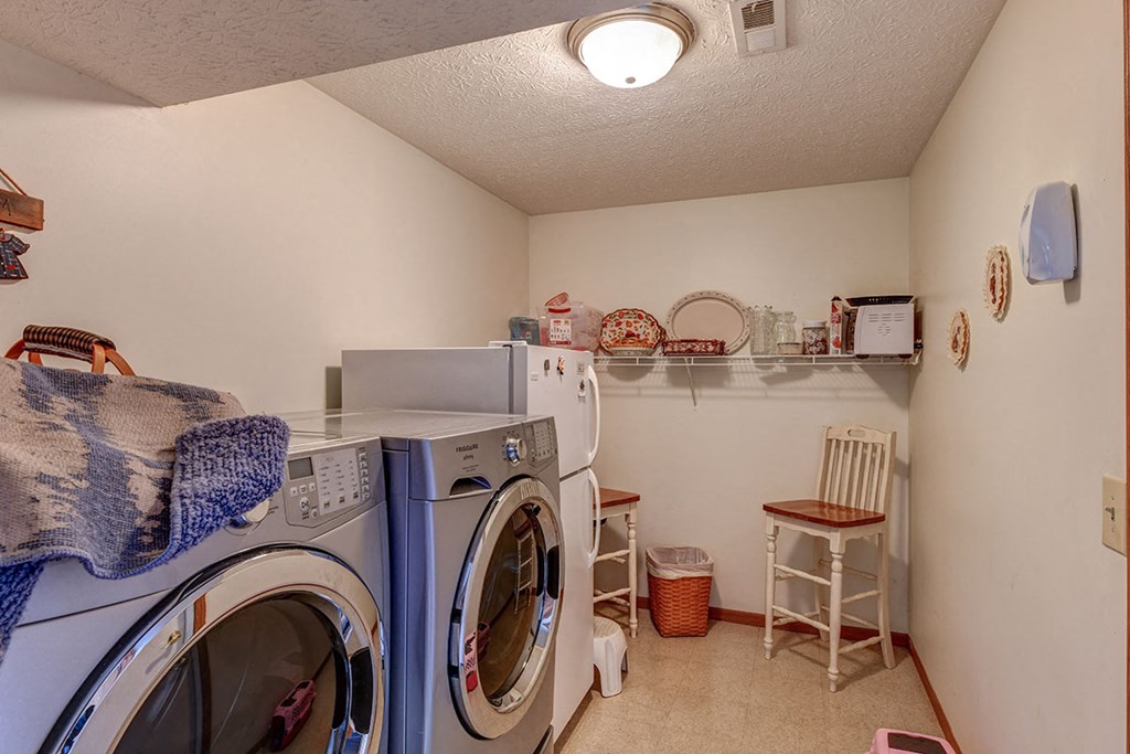 a laundry room with a washing machine and a refrigerator