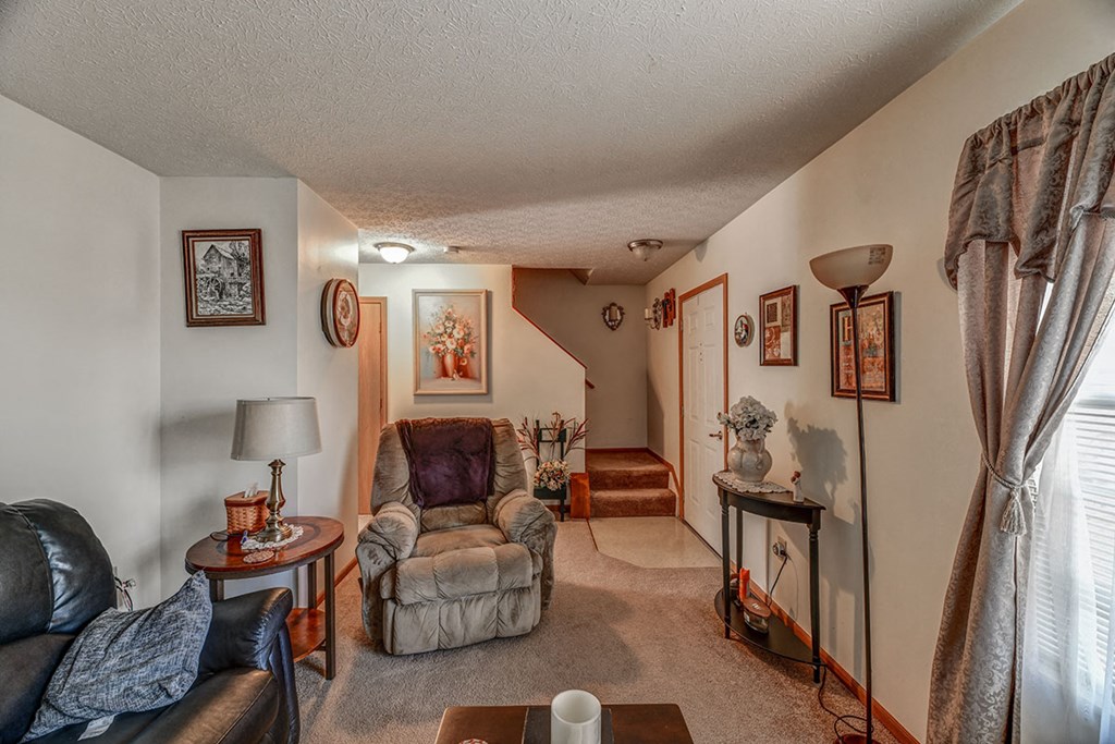 a living room with two chairs and a door to a hallway