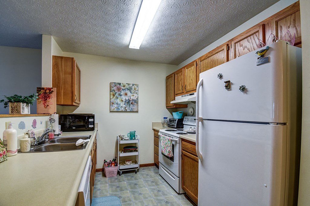 a kitchen with white appliances and a refrigerator
