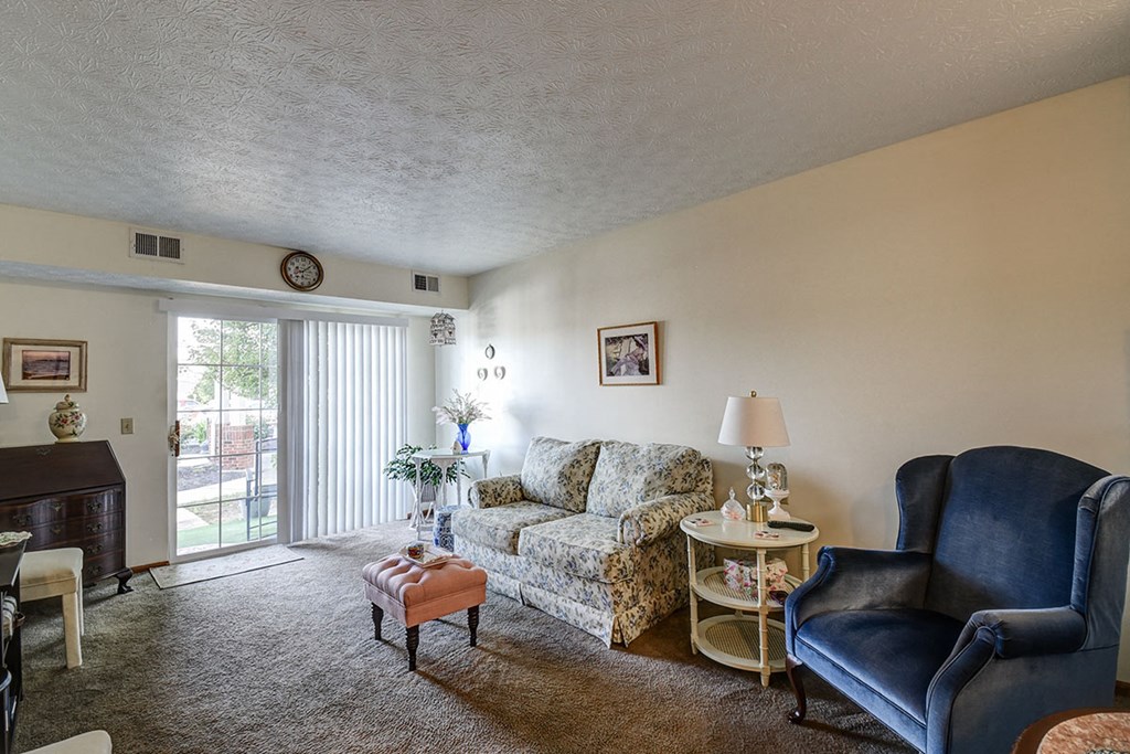 a living room with a couch and chairs and a sliding glass door