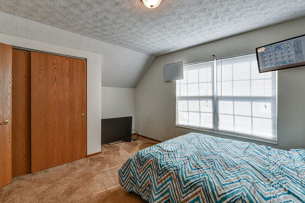 a bedroom with a bed and a window