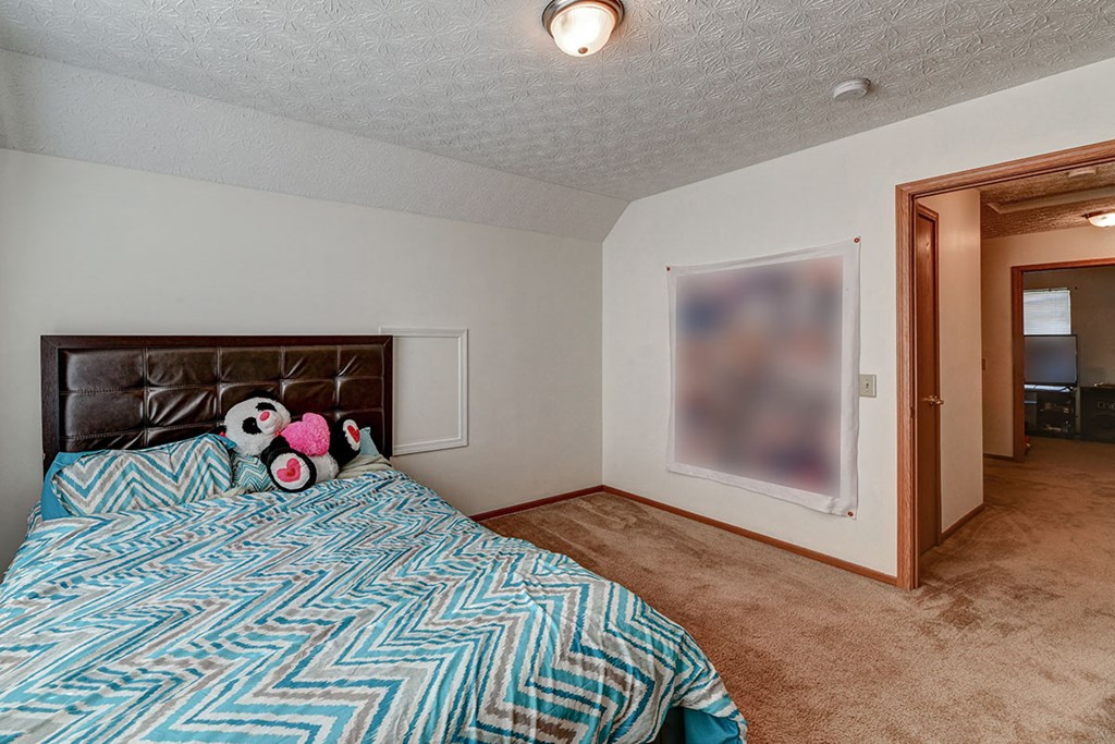 a bedroom with a bed and a door to a bathroom