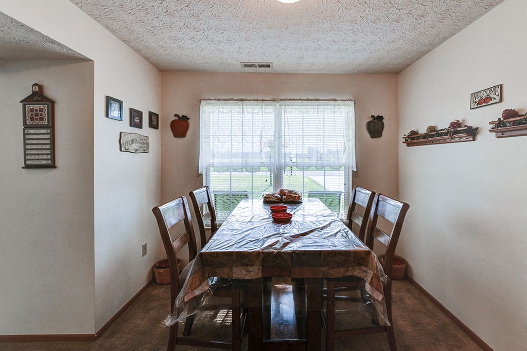 a dining room with a table and chairs and a window