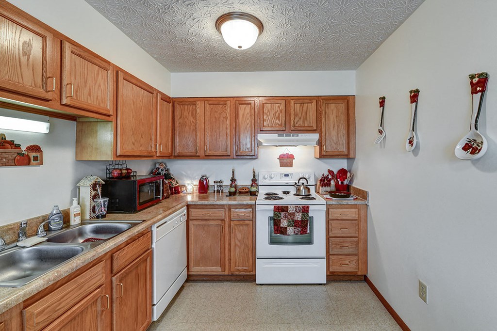 a kitchen with white appliances and wooden cabinets