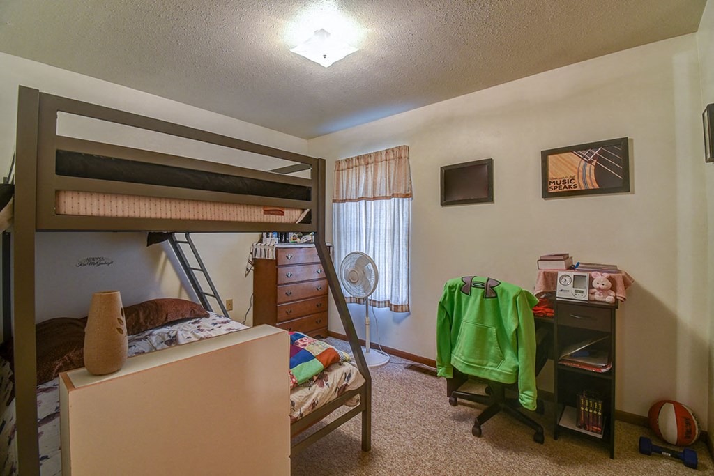 a bedroom with a bunk bed and a desk