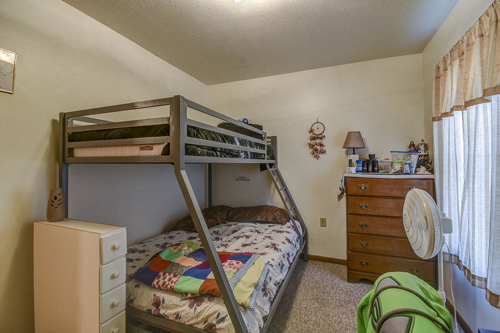 a bedroom with bunk beds and a fan