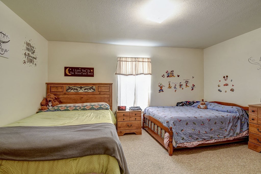 a bedroom with two beds and a window