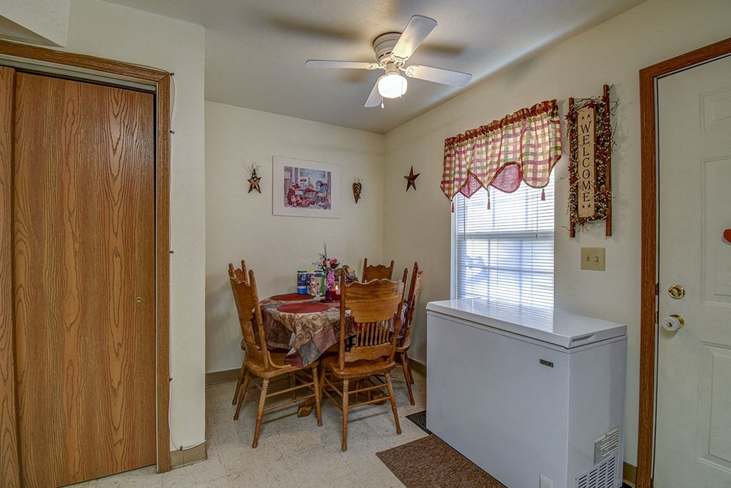 a dining room with a table and chairs and a refrigerator