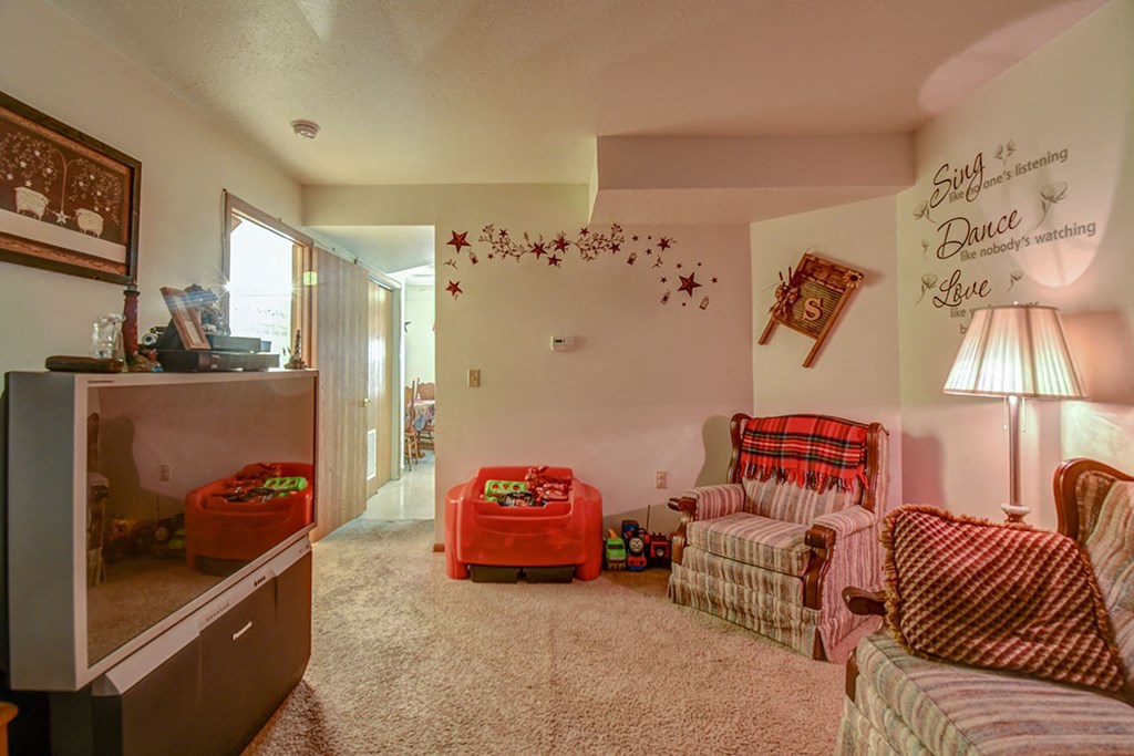 a living room with two couches and a chair and a wall with a message