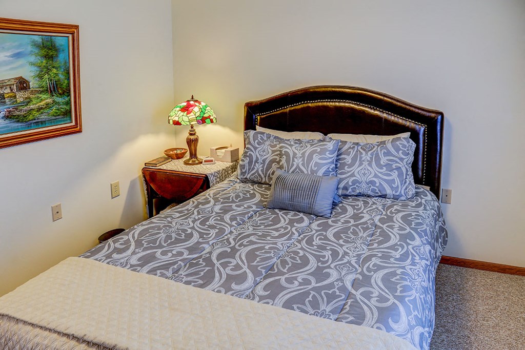 a bedroom with a bed and a table with a lamp